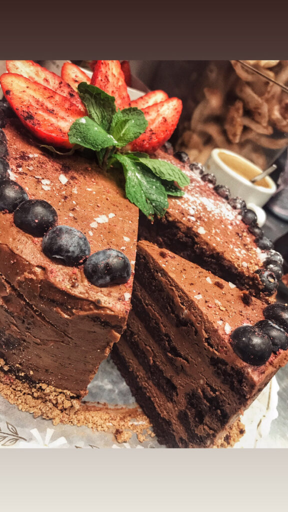 a chocolate cake with strawberries and mint leaves