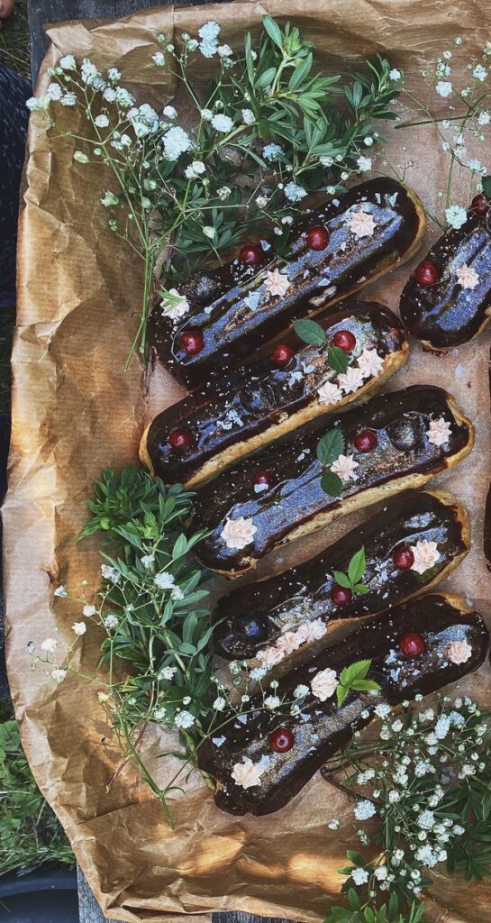 a box of éclairs with flowers and leaves